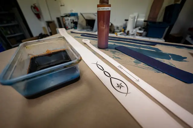 A strap blank beside a tray of dye