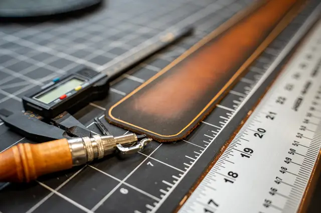 Creasing the edge of a leather strap with a hand tool